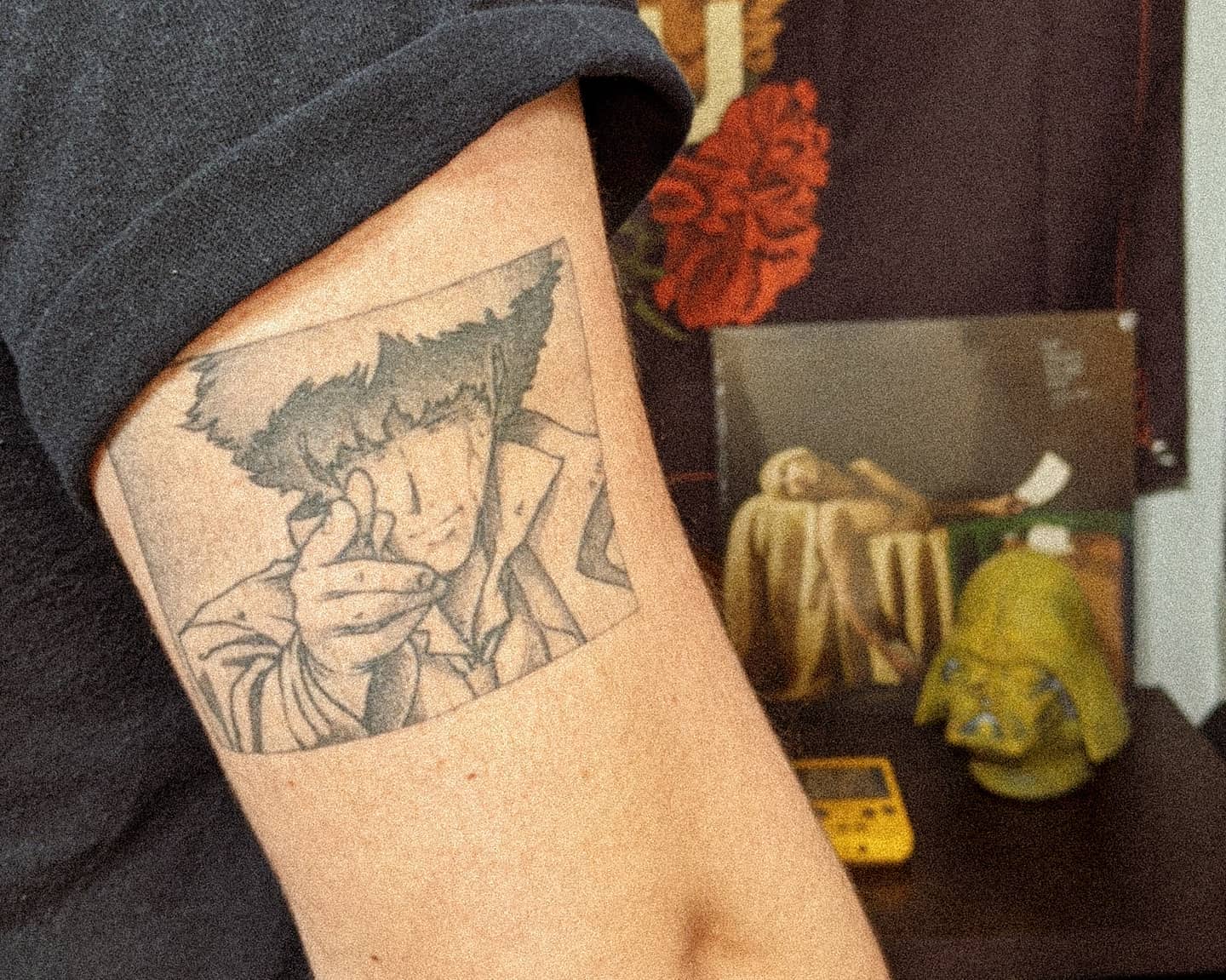 Tattoo of Spike Spiegel from Cowboy Bebop, pointing a finger gun in a classic pose within a rectangular frame